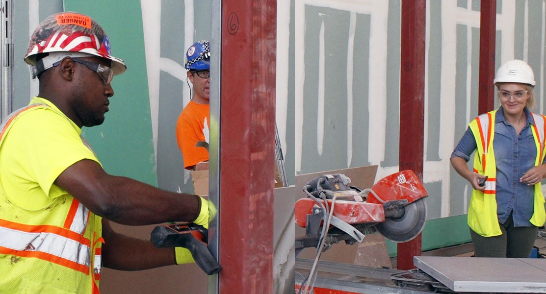 Construction workers of different genders and racial backgrounds working together.